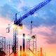 tower cranes at construction site with sun